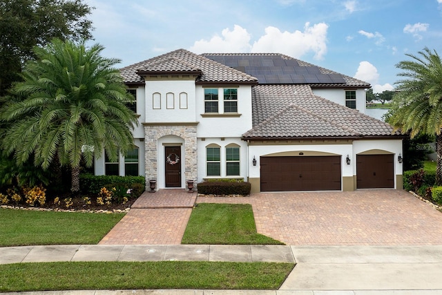 mediterranean / spanish-style home with a garage and a front yard