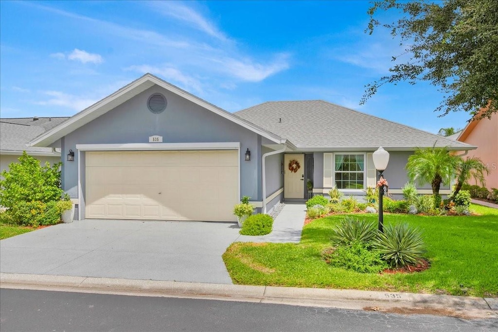 single story home featuring a front lawn and a garage