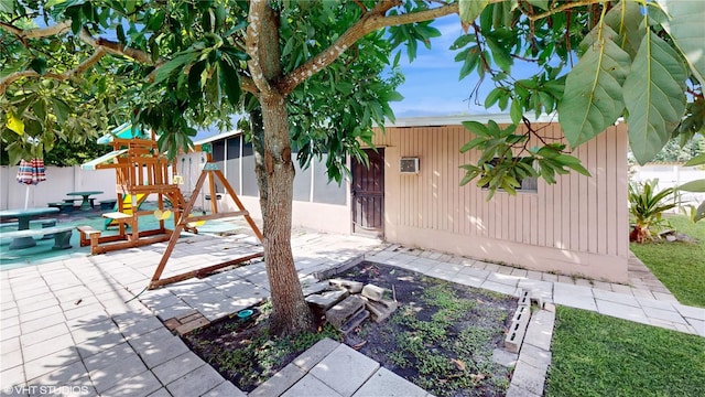 exterior space with a playground and a patio