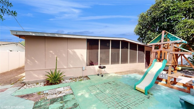 view of play area featuring a patio and a sunroom