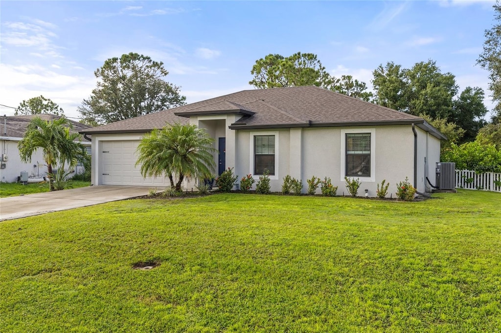 view of front of home featuring a garage, central AC unit, and a front yard