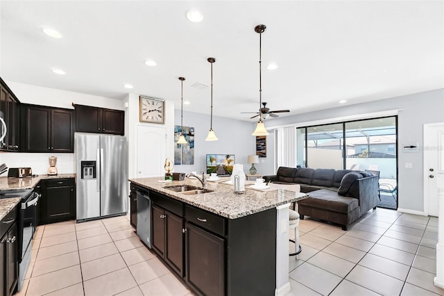 kitchen featuring a kitchen island with sink, pendant lighting, sink, ceiling fan, and appliances with stainless steel finishes