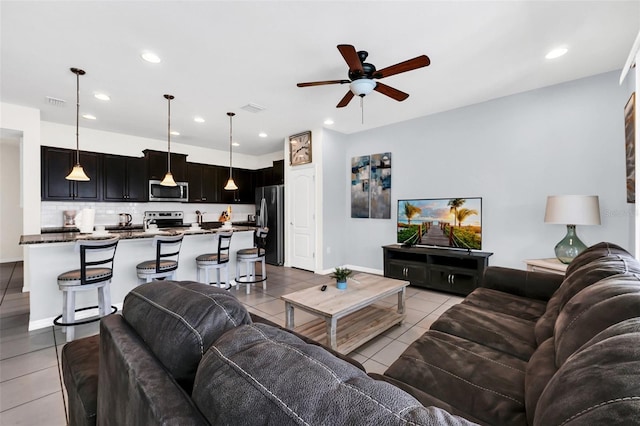 living room featuring ceiling fan, sink, and light tile patterned flooring