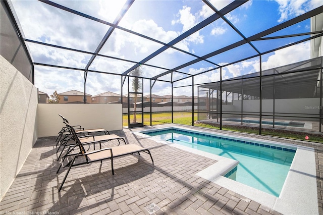 view of swimming pool featuring a lanai and a patio