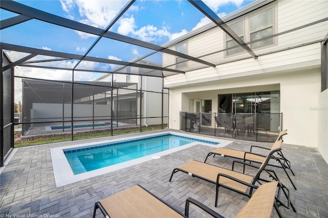 view of swimming pool with a patio and a lanai