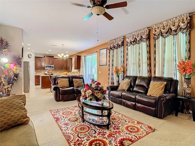 living room with ceiling fan with notable chandelier