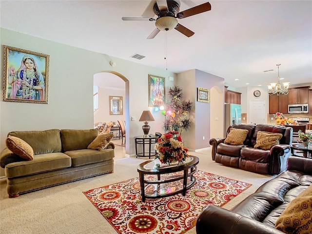 living room with ceiling fan with notable chandelier