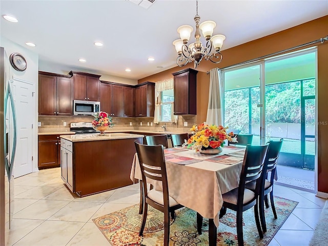 tiled dining area with sink and a notable chandelier