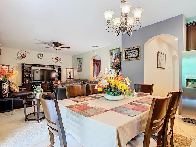 dining space with ceiling fan with notable chandelier