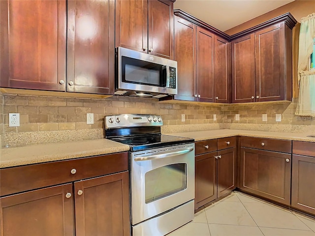 kitchen featuring tasteful backsplash, light tile patterned floors, stainless steel appliances, and light stone counters