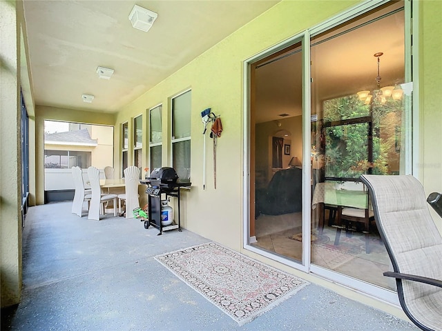 sunroom / solarium with a healthy amount of sunlight and an inviting chandelier