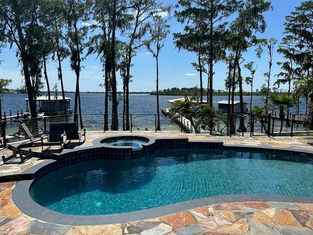 view of swimming pool with an in ground hot tub, a patio, and a water view