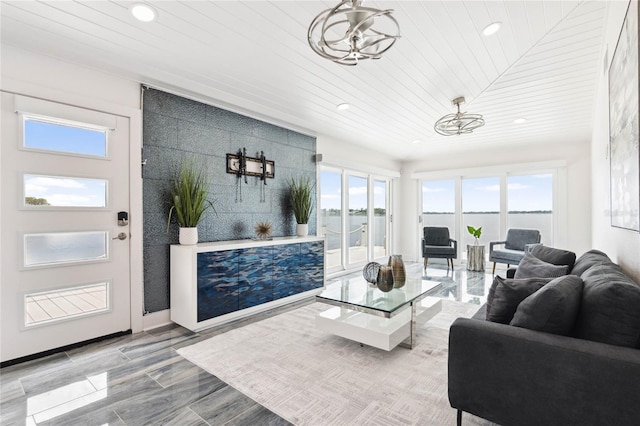 living room featuring wood ceiling, a wealth of natural light, light wood-type flooring, and an inviting chandelier