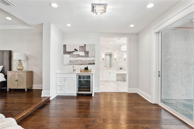 bar with wine cooler, white cabinetry, dark hardwood / wood-style flooring, and sink