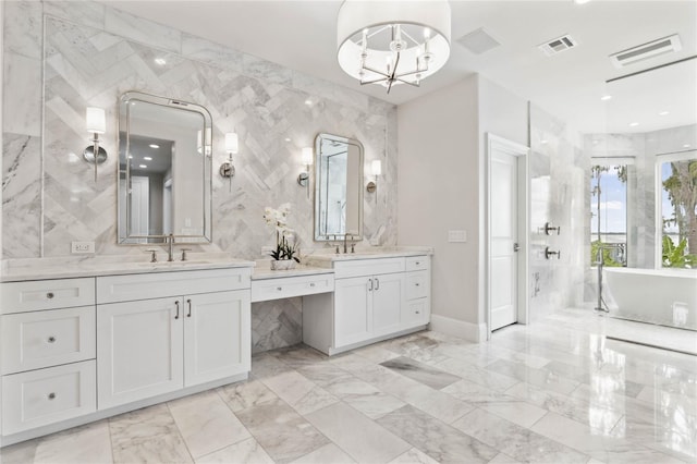 bathroom with a chandelier, a bath, vanity, and tile walls