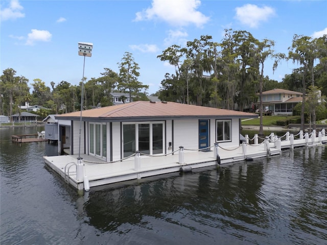 rear view of house with metal roof and a water view