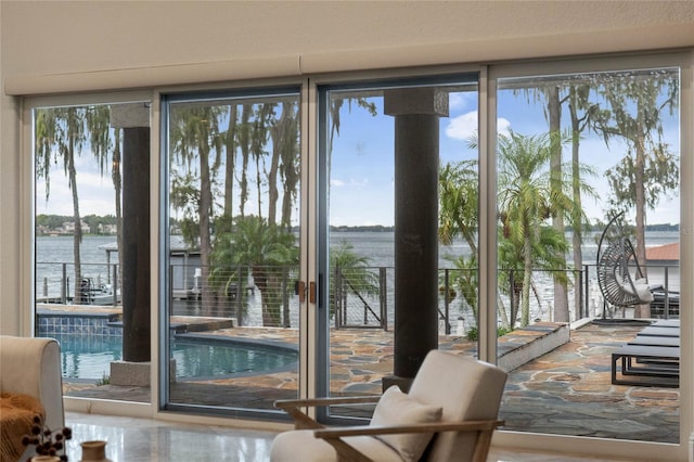 entryway with a wealth of natural light, a wall of windows, and a water view