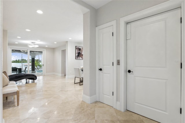 hall featuring recessed lighting and baseboards