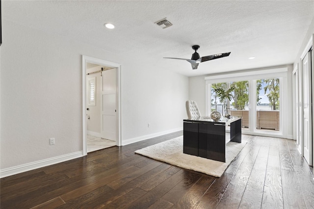 office space featuring visible vents, a textured ceiling, baseboards, and wood-type flooring