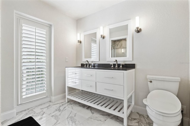 bathroom with vanity, toilet, baseboards, and marble finish floor