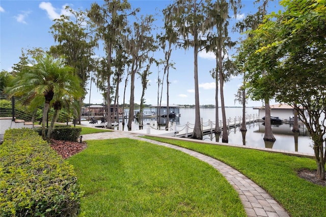 view of dock featuring boat lift, a lawn, and a water view