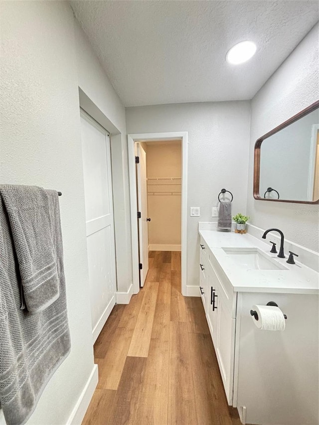 bathroom with wood-type flooring, a textured ceiling, and vanity