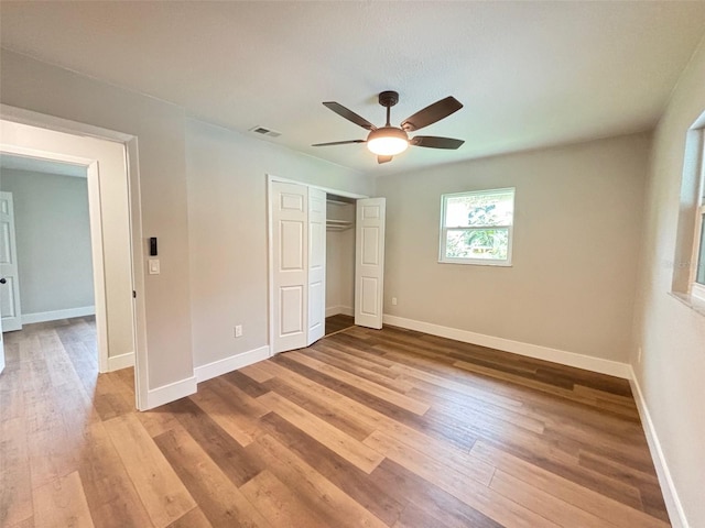 unfurnished bedroom featuring hardwood / wood-style flooring, ceiling fan, and a closet