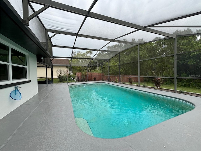 view of swimming pool with glass enclosure and a patio area