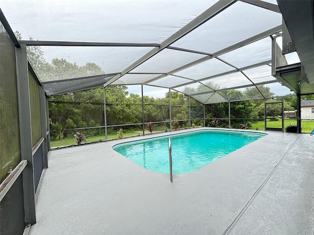 view of swimming pool featuring glass enclosure and a patio