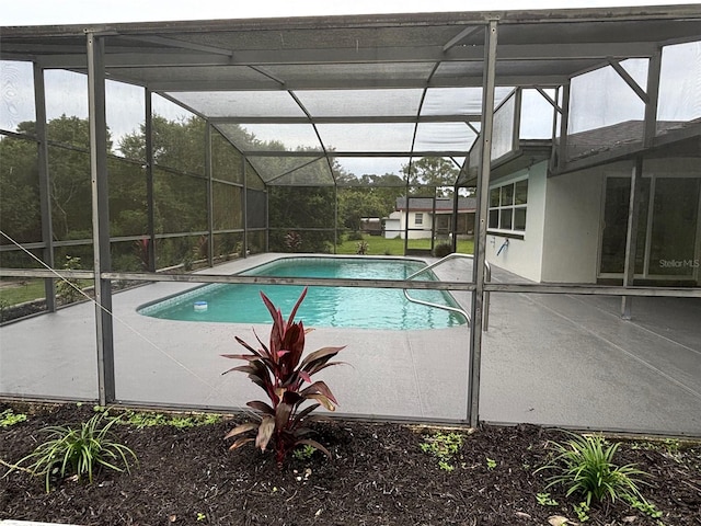 view of swimming pool featuring a lanai and a patio