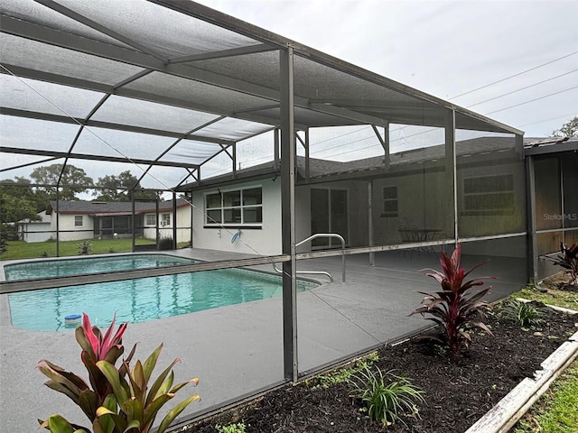 view of pool with a patio area and glass enclosure