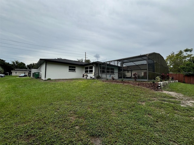 back of property with a lawn and a lanai