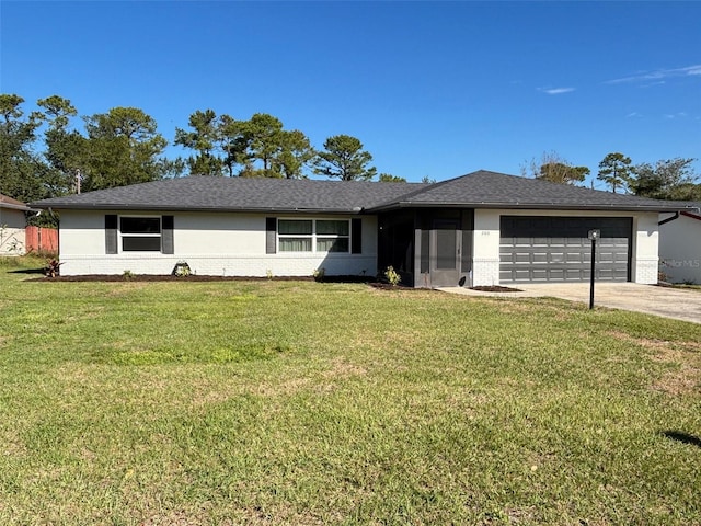 single story home with a garage, concrete driveway, brick siding, and a front yard