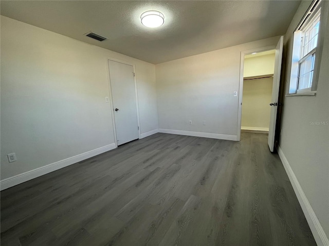 empty room featuring wood-type flooring and a textured ceiling