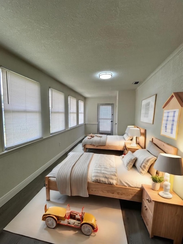 bedroom featuring a textured ceiling and dark hardwood / wood-style floors