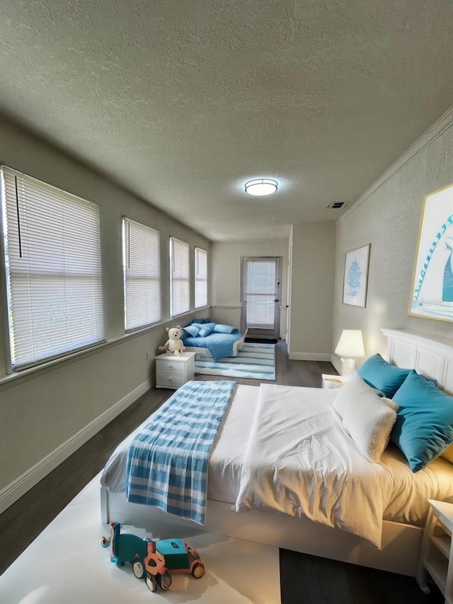 bedroom with a textured ceiling and wood-type flooring