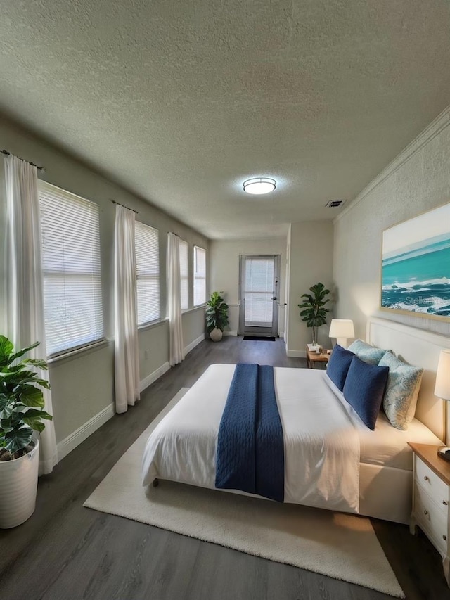 bedroom with dark hardwood / wood-style flooring and a textured ceiling