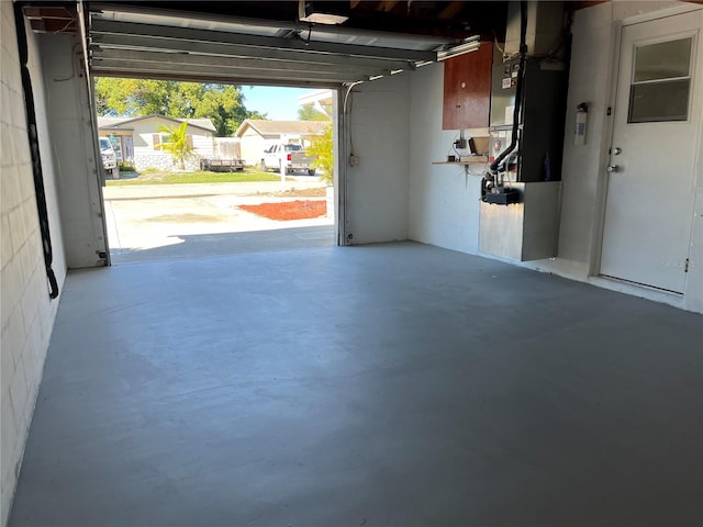 garage featuring a garage door opener and heating unit