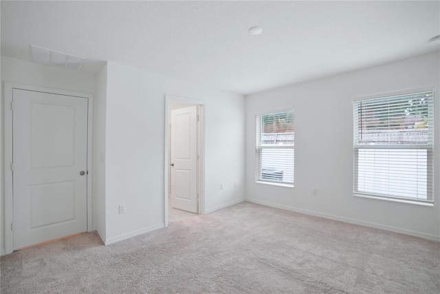 unfurnished bedroom with multiple windows and light colored carpet