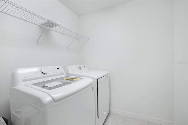 clothes washing area featuring washing machine and clothes dryer and light carpet