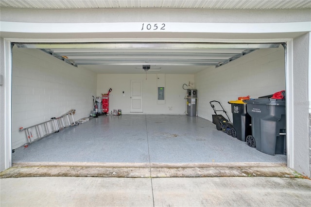 garage featuring water heater, electric panel, and a garage door opener