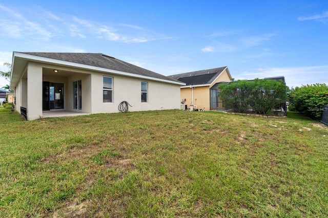 back of property featuring a yard and a patio area