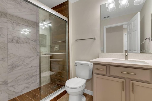 bathroom with vanity, toilet, and a shower with shower door