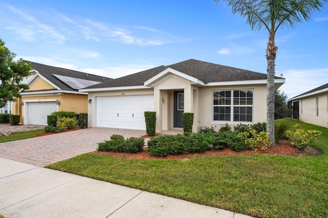 ranch-style house featuring solar panels, a garage, and a front lawn