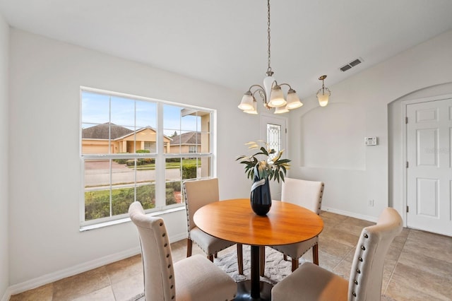 tiled dining area with a wealth of natural light and a chandelier