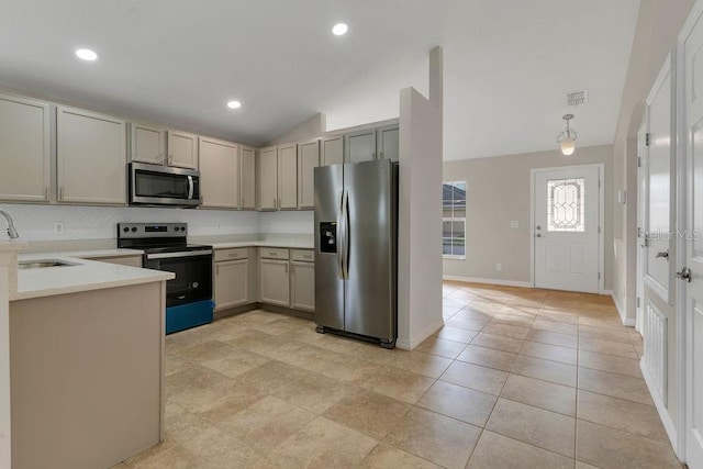 kitchen with appliances with stainless steel finishes, gray cabinets, vaulted ceiling, and sink