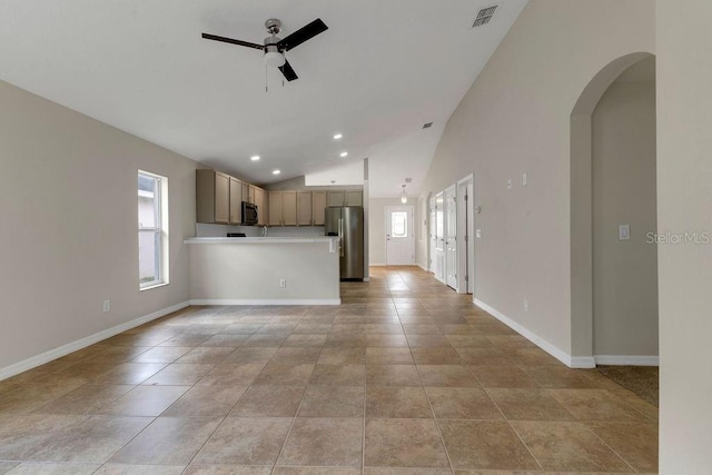 unfurnished living room with ceiling fan, light tile patterned floors, and lofted ceiling