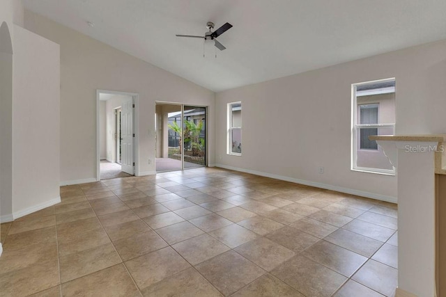 tiled empty room with ceiling fan and high vaulted ceiling