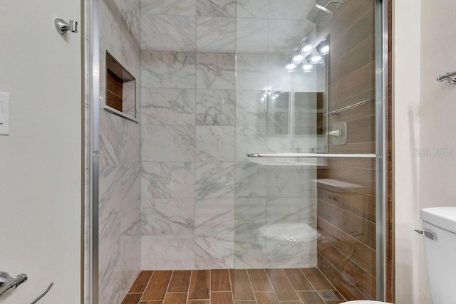 bathroom with toilet and an enclosed shower