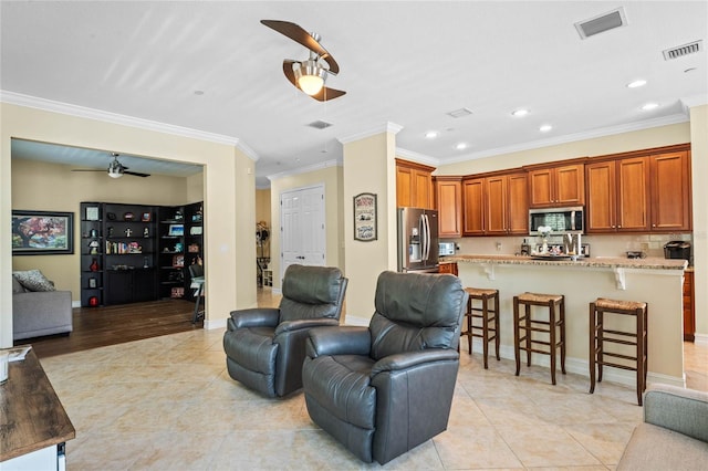 tiled living room featuring crown molding and ceiling fan